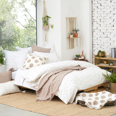 Mel Dune Duvet Cover and Pillows featuring a boho-chic texture of indigo dobby weave details.  Complemented by Dot Dune Decorative Pillow and Dot Dune Throw and Tabb Dune & White Decorative Pillow and Tabb Dune & White Throw.