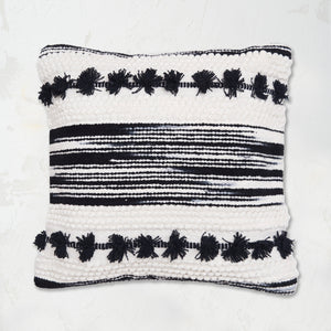 Oriana Onyx Pillow builds a unique pattern through texture with hand woven zig zags and stripes, tufted dots, and hand-tied mini tassels.
