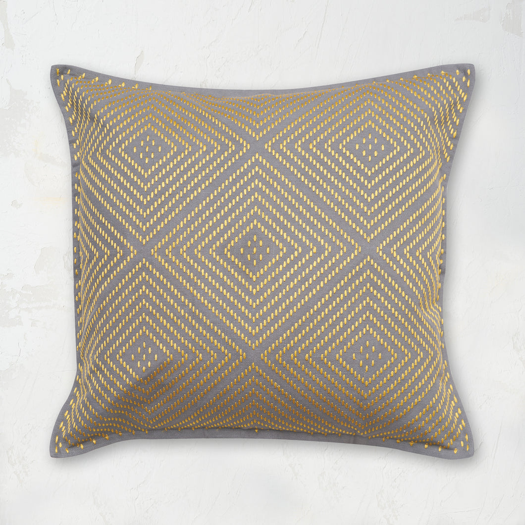 Virginia Boulder Pillow decorated with a geometric and symmetrical embroidered diamond design.