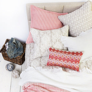 darla decorative throw pillow with an ikat design in pink on a bed