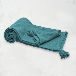 teal woven devin throw blanket with tassel detail on the corners