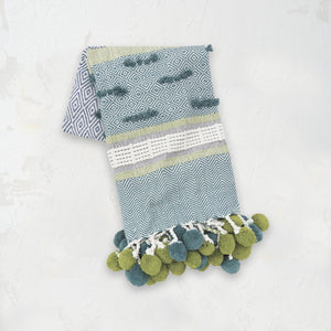 green blue and white patterned highland throw blanket with pom pom tassel fringe