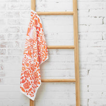 orange hummingbird and floral patterned kitchen towel hanging on ladder