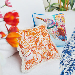 orange and white hummingbird floral design pillow with fringe