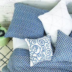 indigo swirl decorative throw pillow styled on a bed