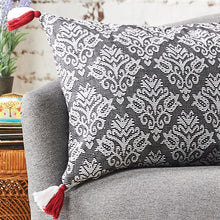 lottie floral decorative pillow in gray white and red on a sofa