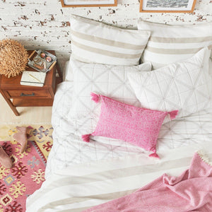 noland tan and white pinstripe duvet cover styled with pink accents