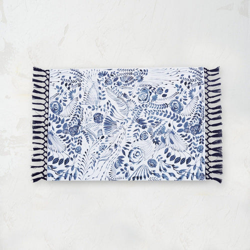starla placemat with an indigo and white screen printed floral pattern and tassel fringe